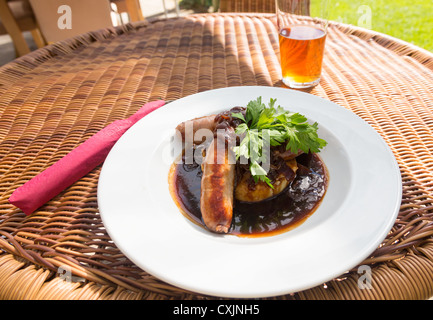 Saucisses traditionnelles et écrasez-les avec la sauce servi en plein air avec de la bière dans un pub anglais Banque D'Images