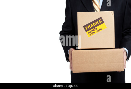 Homme dans un costume d'affaires holding moving boxes avec une fragile sticker sur elle sur un fond blanc Banque D'Images