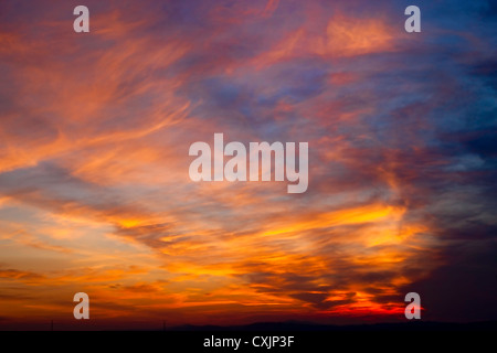 Le soleil couchant jette une lueur orange sur les nuages. Banque D'Images