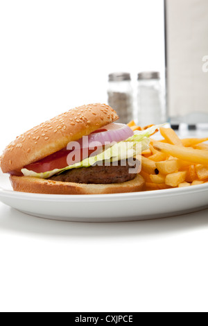 Hamburger et frites, avec porte-serviettes avec sel et poivre shaker sur fond blanc avec copie espace Banque D'Images