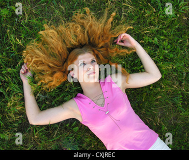 Jeune femme rousse allongée sur l'herbe en été 24 Banque D'Images