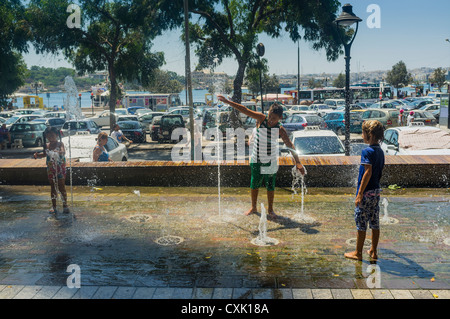Trois enfants qui jouent dans une fontaine ornementale dans la ville de Sliema à Malte Banque D'Images