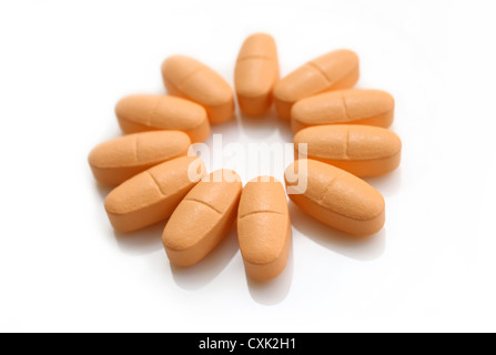 Comprimés orange sur fond blanc Banque D'Images