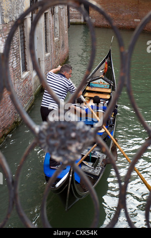 Gondola passant sous un pont dans un petit canal à Venise, Italie Banque D'Images