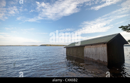 Petit bateau en bois garage sur la côte du lac Saimaa, construction typiquement pour la Finlande Banque D'Images