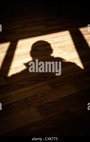 Ombre d'un homme sur un sol en bois Banque D'Images