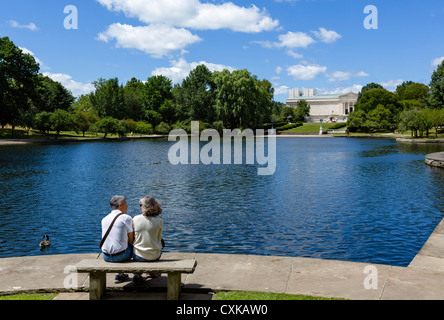 Couple assis sur un banc, par Wade Lagoon Cleveland Museum of Art derrière, University Circle, District de l'Ohio, USA Banque D'Images