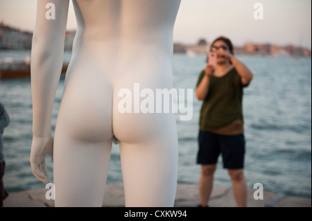 Un touriste à prendre des photos de la statue de Charles Ray "garçon avec une grenouille", Venise, Italie. Banque D'Images