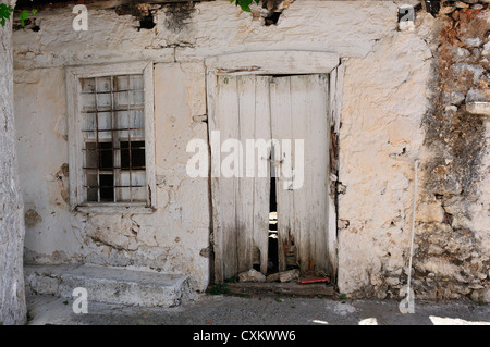 Ancienne maison grecque avec porte et fenêtre dans l'agriculture de montagne village de Kroustas, près de Agios Nikolaos, Crète, Grèce Banque D'Images