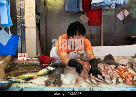 Poissonnier fumeurs sur le travail à un marché traditionnel de Hong Kong Banque D'Images