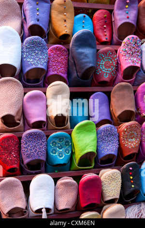 Chaussons en cuir coloré marocain sur l'affichage mural. Banque D'Images