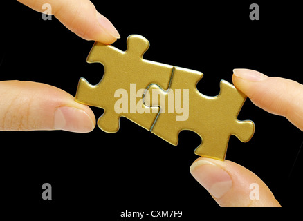 Puzzle dans la main isolé sur fond noir Banque D'Images