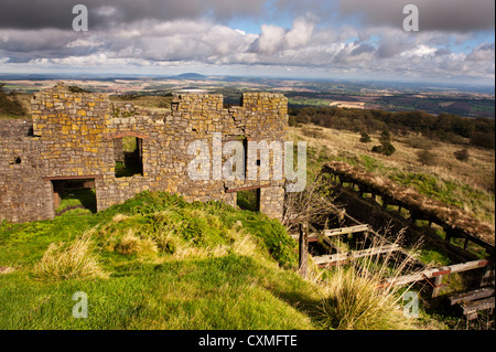 Les bâtiments de l'ancienne mine abandonnée en haut de Brown Clee Hill, avec la colline Wrekin dans la distance, le Shropshire Banque D'Images