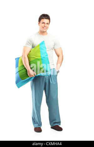 Portrait of a smiling man in pajamas holding un oreiller isolé sur fond blanc Banque D'Images