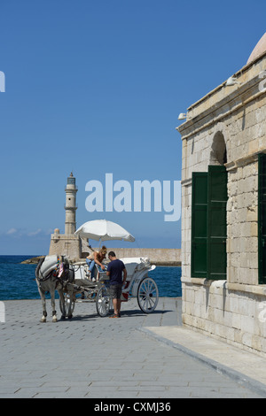 Transport de chevaux passant Kioutsouk Hassan mosquée sur promenade du front de mer, Chania, Chania, Crete, Crete Région Région, Grèce Banque D'Images