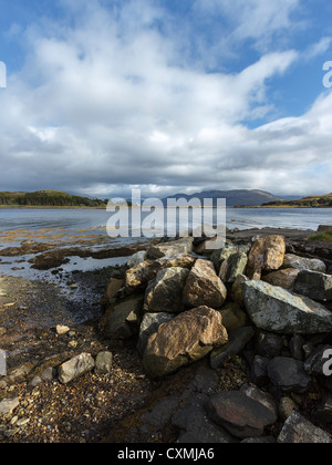 Rivage rocheux à Isle Ornsay avec phare, Sound of Sleat et les montagnes au-delà de Knoydart, Isle of Skye, Scotland, UK Banque D'Images