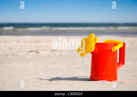 Arrosoir sur la plage de sable tropicale de l'océan avec en arrière-plan Banque D'Images