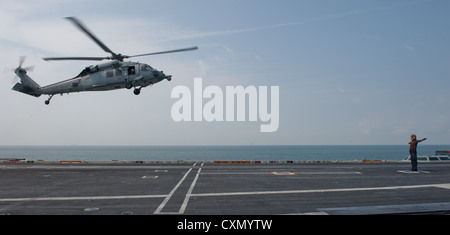 Détroit de Malacca (oct. 6, 2012) un MH-60s knighthawk à partir de l'hélicoptère de combat eightballers mer escadron 8 retourne à la classe nimitz porte-avions USS John C. Stennis après avoir sauvé un homme à la mer pendant la traversée du détroit de Malacca. John C. Stennis est de retour au 7è et 5e flotte domaines de responsabilité quatre mois avant la date prévue afin de maintenir les exigences de la marine et commandant de combat actif dans la région. Banque D'Images