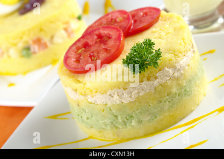 Plat péruvien appelé causa, qui est faite de purée de pommes de terre jaunes, et ici, rempli avec de l'avocat et le poulet Banque D'Images