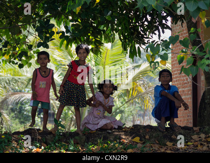 Quatre enfants Indiens regarder à partir de la banque d'un canal dans les Backwaters du Kerala Banque D'Images