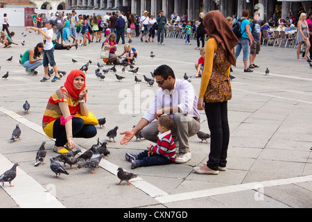 L'alimentation de la famille dans les pigeons de la place Saint Marc Venise Italie Banque D'Images