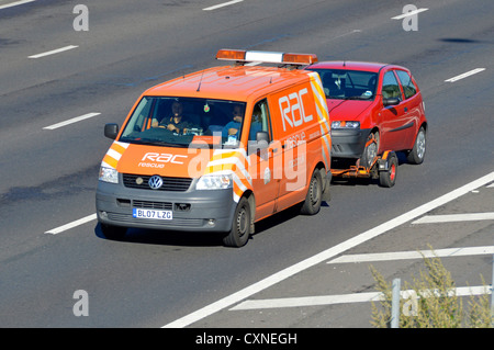 Vue latérale et avant du logo de la marque sur le RAC VW Volkswagen panne de la camionnette commerciale, remorquage du conducteur et du passager, rouge, panne Voiture sur l'autoroute britannique Angleterre Banque D'Images