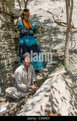 Femme Kalash à parler à une mobilité Carpenter, vallée de Rumbur, Chitral, Khyber-Pakhtunkhwa, Pakistan Banque D'Images