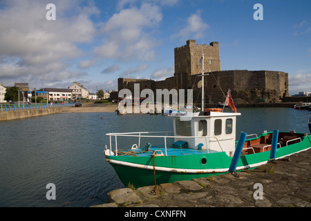 Carrickfergus Co Antrim Irlande du Nord les bateaux de pêche amarrés au port avec l'imposant château construit sur le promontoire rocheux derrière Banque D'Images