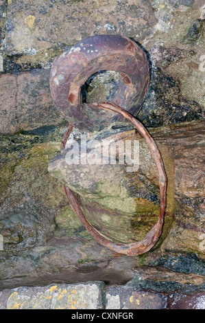 Vieux fer rouillé anneau d'amarrage situé dans vieux mur de pierre Banque D'Images