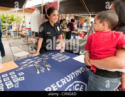 Portrait policier parle de femme exerçant son jeune fils à Austin Police Department stand recrutement festival en plein air Banque D'Images