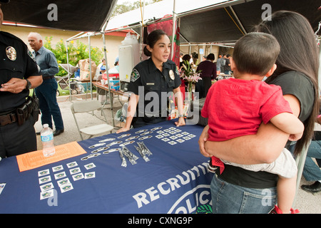 Portrait policier parle de femme exerçant son jeune fils à Austin Police Department stand recrutement festival en plein air Banque D'Images