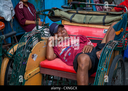 Dormir conducteur de pousse-pousse à Yogyakarta en Indonésie Banque D'Images