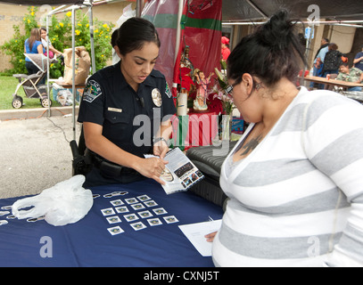 Les jeunes hispaniques policière parle de femme à Austin Police Department kiosque de recrutement à un festival de l'église en plein air Banque D'Images