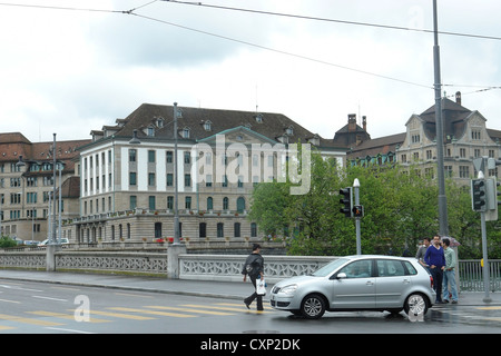 Les gens et en voiture sur pont sur rivière Limmat à Zurich. A récemment plu et une maison de vacances, si faible circulation et moins de gens autour. Banque D'Images