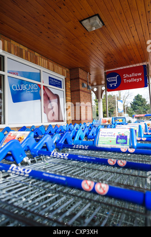 En dehors d'un chariots de supermarché Tesco clubcard avec un signe dans l'arrière-plan Banque D'Images