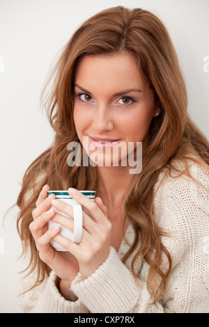 Portrait d'une belle jeune femme tenant une tasse ou mug de café ou thé Banque D'Images