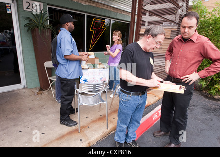 Registre d'état civil vote adjoint bénévole de nouveaux électeurs à table, à l'extérieur sandwich shop pendant le déjeuner peu avant l'élection dans Austin TX. Banque D'Images