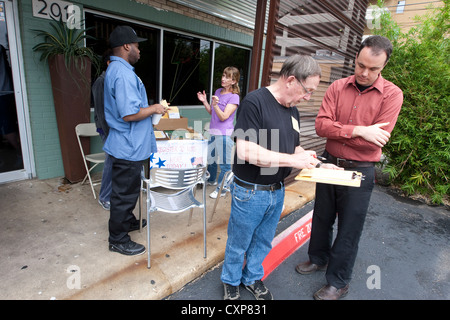 Registre d'état civil vote adjoint bénévole de nouveaux électeurs à table, à l'extérieur sandwich shop pendant le déjeuner peu avant l'élection dans Austin TX. Banque D'Images