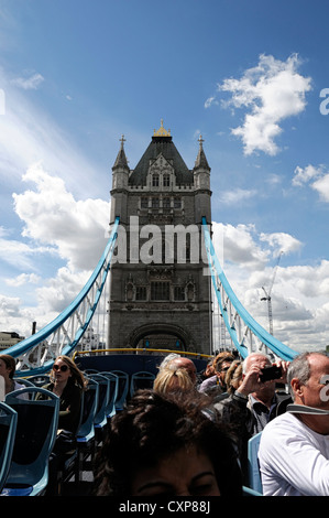 Les touristes appréciant open top bus tour de Londres en passant sous le pont de Londres Banque D'Images