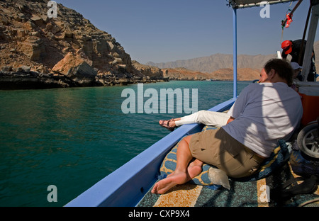 Les touristes se détendre pendant un dhow croisière de Khasab à Telegraph Island sur la péninsule de Musandam, Oman Banque D'Images