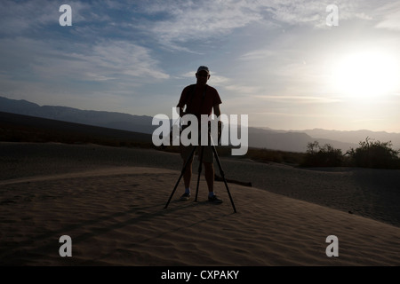 Silhouette homme adulte photographe avec trépied et appareil photo de dunes de Mesquite Dunes Death Valley National Park Californie Banque D'Images