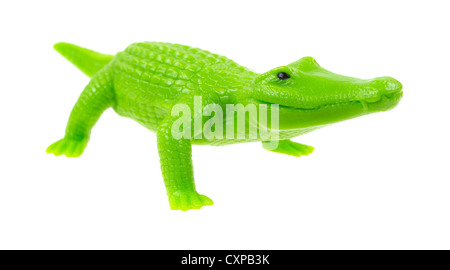 Un petit jouet alligator vert en plastique sur un fond blanc. Banque D'Images