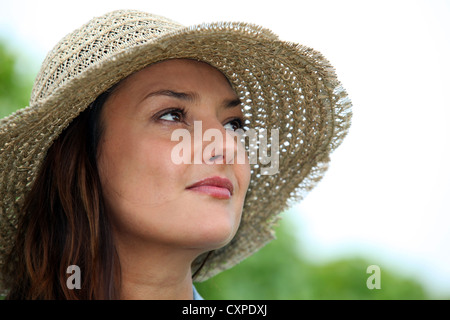 Femme portant un chapeau de paille Banque D'Images