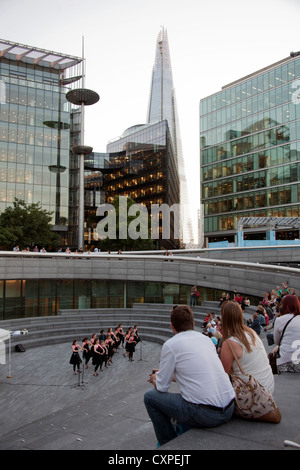 Les gens qui regardent une performance à l'écope, une piscine en plein air à l'amphithéâtre englouti plus de Londres avec le fragment dans l'arrière-plan. Banque D'Images