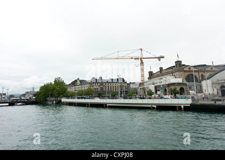 Passage de tram Pont sur la Limmat à Zurich. Beaucoup d'activité sur le côté de la rivière, y compris une énorme grue. Banque D'Images