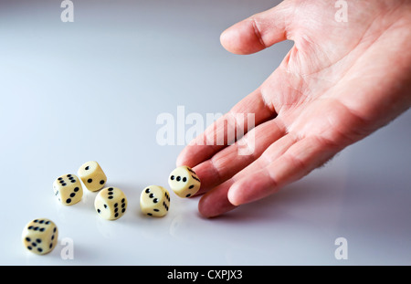La main de la personne lançant cubes pour découper. Banque D'Images