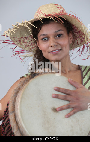 Femme portant un chapeau de paille et de jouer le djembé Banque D'Images