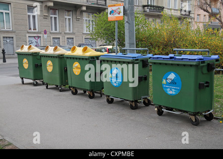 Une ligne de grands bacs de recyclage (vert-jaune pour le plastique et métal-bleu) dans un quartier résidentiel de Vienne (Wien), l'Autriche. Banque D'Images