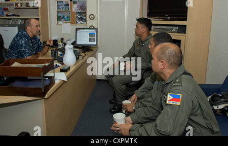 Le capt. CATHAL O'Connor, commandant de l'escadron amphibie 11, parle avec des membres des forces armées des Philippines à bord du navire d'assaut amphibie USS Bonhomme Richard (DAG 6). Le bonhomme richard groupe amphibie, avec la 31e Marine Expeditionary Unit, participent à l'exercice de débarquement amphibie, qui est un exercice bilatéral annuel tenu conjointement avec l'afp. Bonhomme Richard, commandé par le capt. Daniel dusek, est le premier navire de la seule l'avant-déployée groupe amphibie et est actuellement à la 7ème flotte américaine zone de responsabilité. Banque D'Images