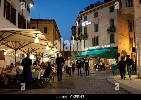 Les touristes à pied le long trottoir restaurants à Vérone, Italie Banque D'Images